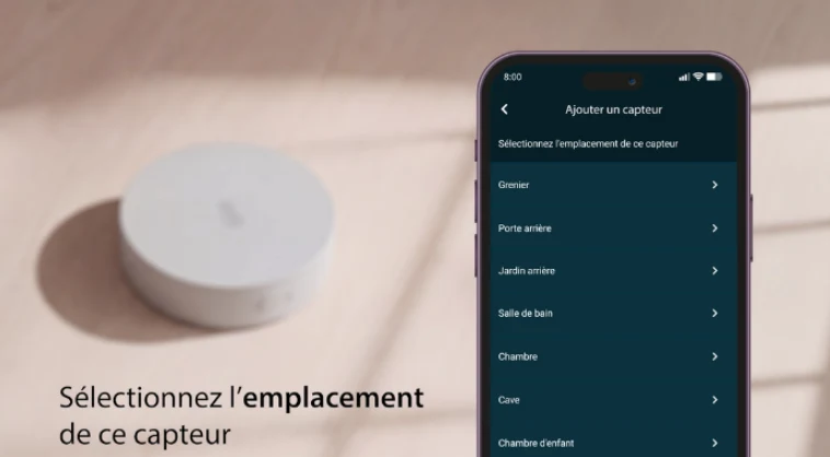 Sonde externe Daikin posée sur une table et smartphone affichant l'application Madoka Assistant pour choisir l'emplacement du capteur